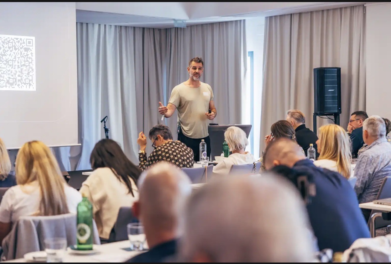 Nico Rolli im Vortrag vor einer Gruppe im Seminarraum