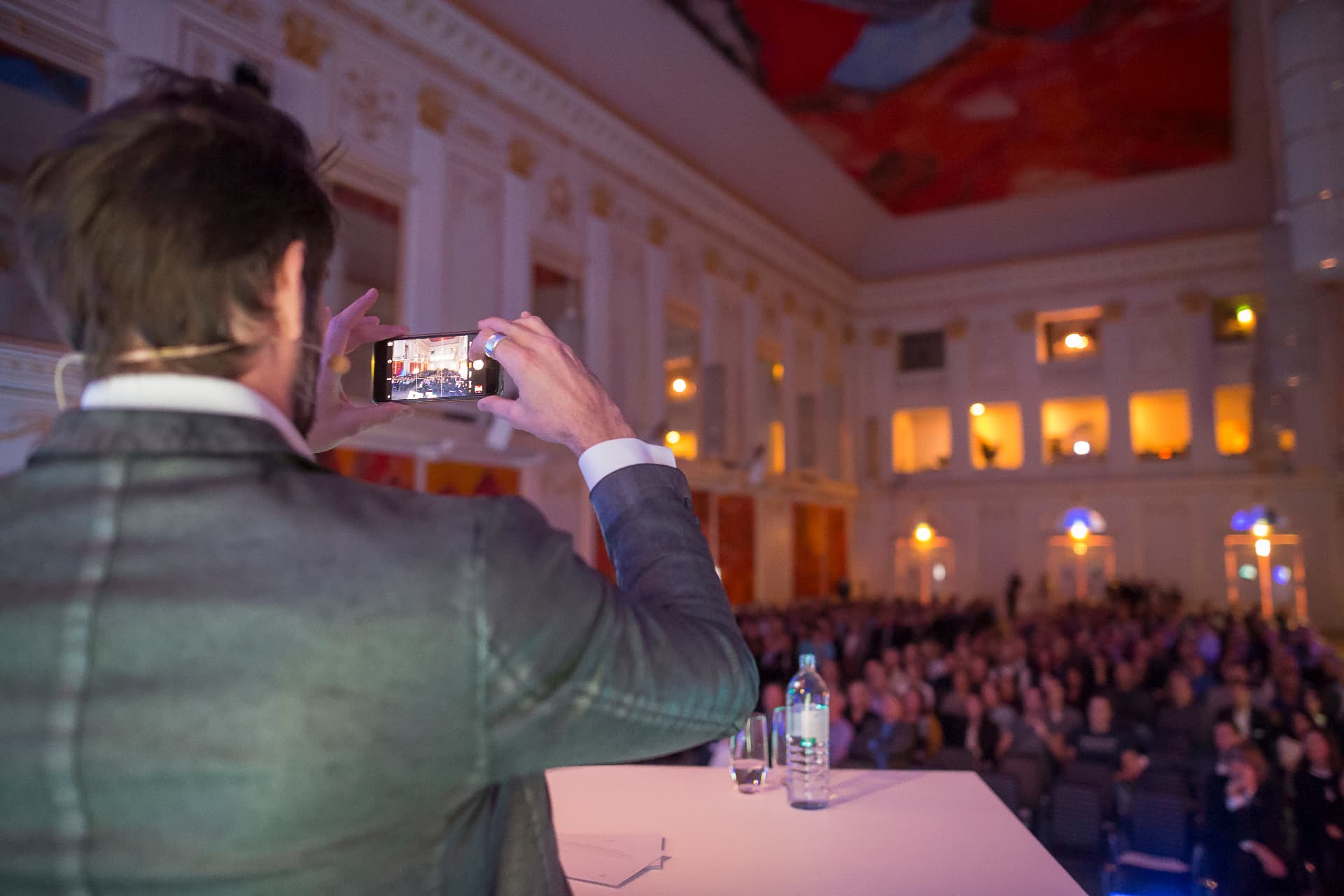 Nico Rolli fotografiert von der Bühne aus den vollen Kongresssaal